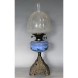 Edwardian cast metal oil lamp with tapered square base cast with various flowers, painted blue glass