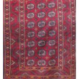 A good old Turkoman rug with Bokara type decoration upon a red ground, 235 x 110cm