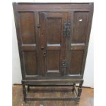 A Georgian oak side or dole cupboard, with panelled framework, central door and iron work cocks-head