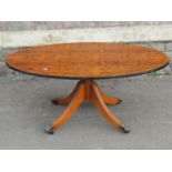 A reproduction Georgian style walnut veneered occasional table, the oval top on turned pillar and