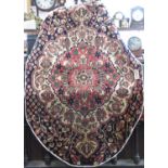 Unusual Bakhtiar rug, of oval form with central red medallion and further scrolled foliage upon a