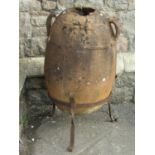 A well weathered terracotta egg shaped urn with moulded loop handles raised/set in a simple iron