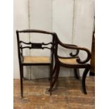 A pair of Regency beechwood sabre leg elbow chairs with simulated rosewood finish, rose twist