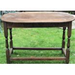 An antique oak occasional table, the oval top enclosing a frieze drawer on turned supports, 115cm