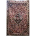 Mahal rug with central medallion and geometric scrolled borders upon a washed red ground, 200 x