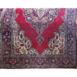 Fine hand woven Tabriz carpet with typical central floral blue medallion upon a red ground, 300 x