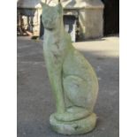 A reclaimed garden ornament in the form of a seated Siamese or Abyssinian cat raised on an oval