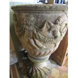 A reclaimed garden urn of circular form with raised repeating cherub and swag detail raised on a