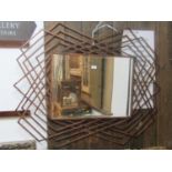 A contemporary wall mirror of rectangular form with bevelled edge plate within a copper-ised metal