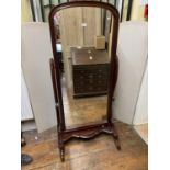 A Victorian style mahogany floorstanding cheval glass, raised on shaped and curved supports and