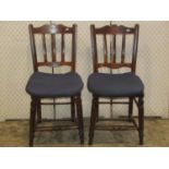 A set of eight Edwardian stick back kitchen chairs in mixed woods, the seats in elm, raised on