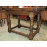 A good quality old English style oak cottage draw leaf dining table raised on four turned supports