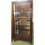 A Chinese hardwood display cabinet of full height, the framework with repeating bamboo detail,