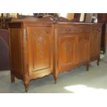 A pale oak breakfront side cupboard enclosed by an arrangement of drawers and cupboards with