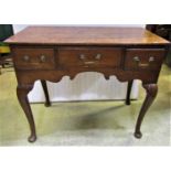 A Georgian country made lowboy fitted with three frieze drawers with shaped apron raised on cabriole