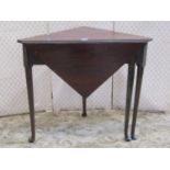 A Georgian mahogany triangular drop leaf corner table raised on four pad feet with gateleg action,