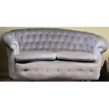 A small upholstered sofa with raised curved button back and concave outline, 160cm wide approx