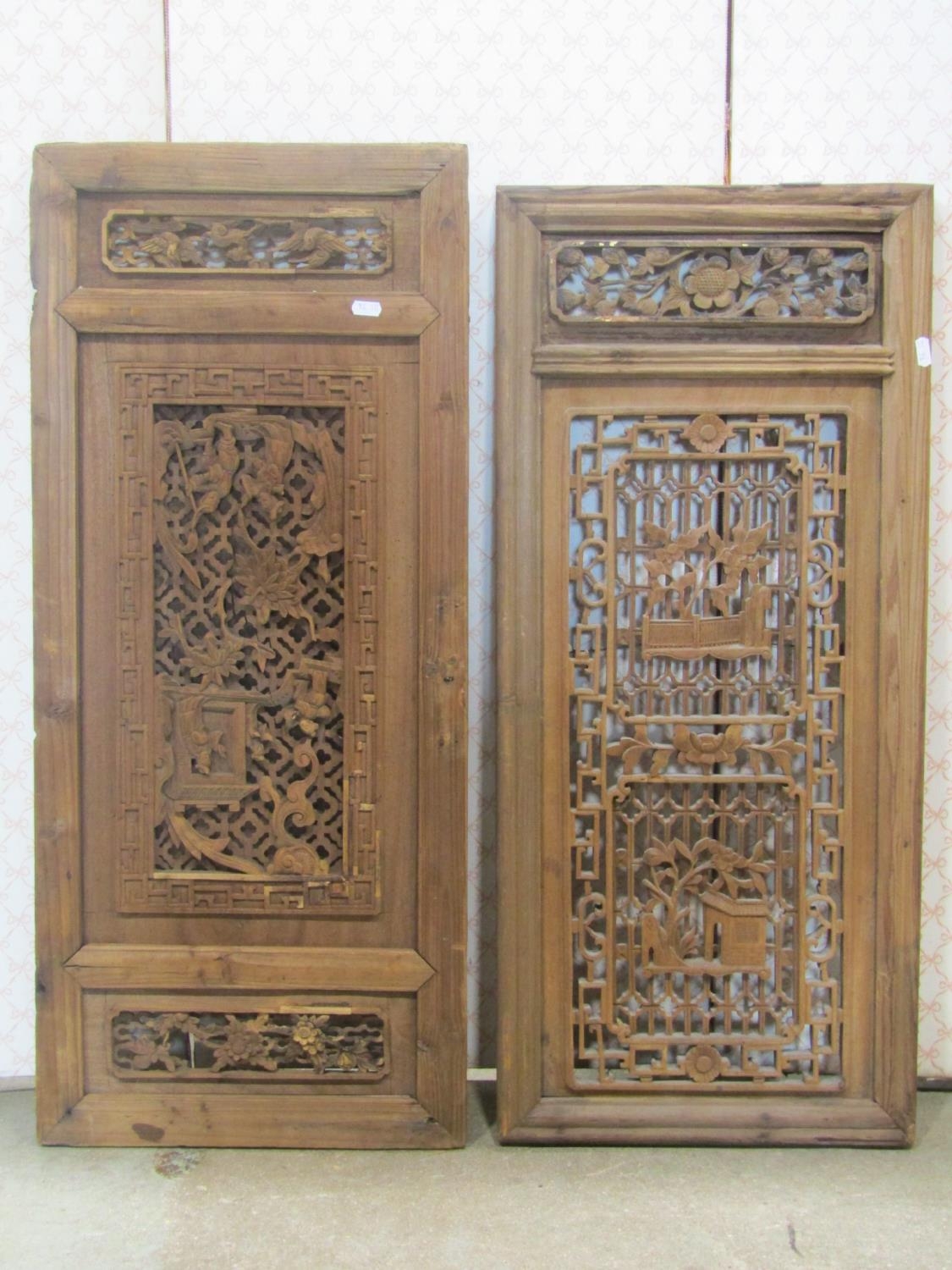 A pair of carved and pierced Chinese pine panels with repeating floral geometric work, 90cm high x