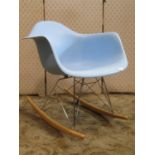 A retro style rocking chair with moulded plastic seat, raised on polished chrome supports with beech