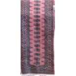 Bokara pattern runner upon a pink ground, 300 x 80cm