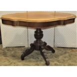 A 19th century mahogany centre table, the shaped outline raised on a turned pillar with carved