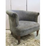 An Edwardian tub chair with horse shoe shaped back on square tapered legs