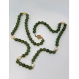 Bead necklace composed of green stone (possibly nephrite), bone and yellow metal beads