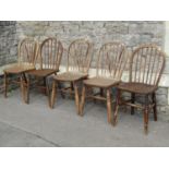 A Harlequin set of five 19th century and later Windsor hoop back kitchen chairs, all with elm