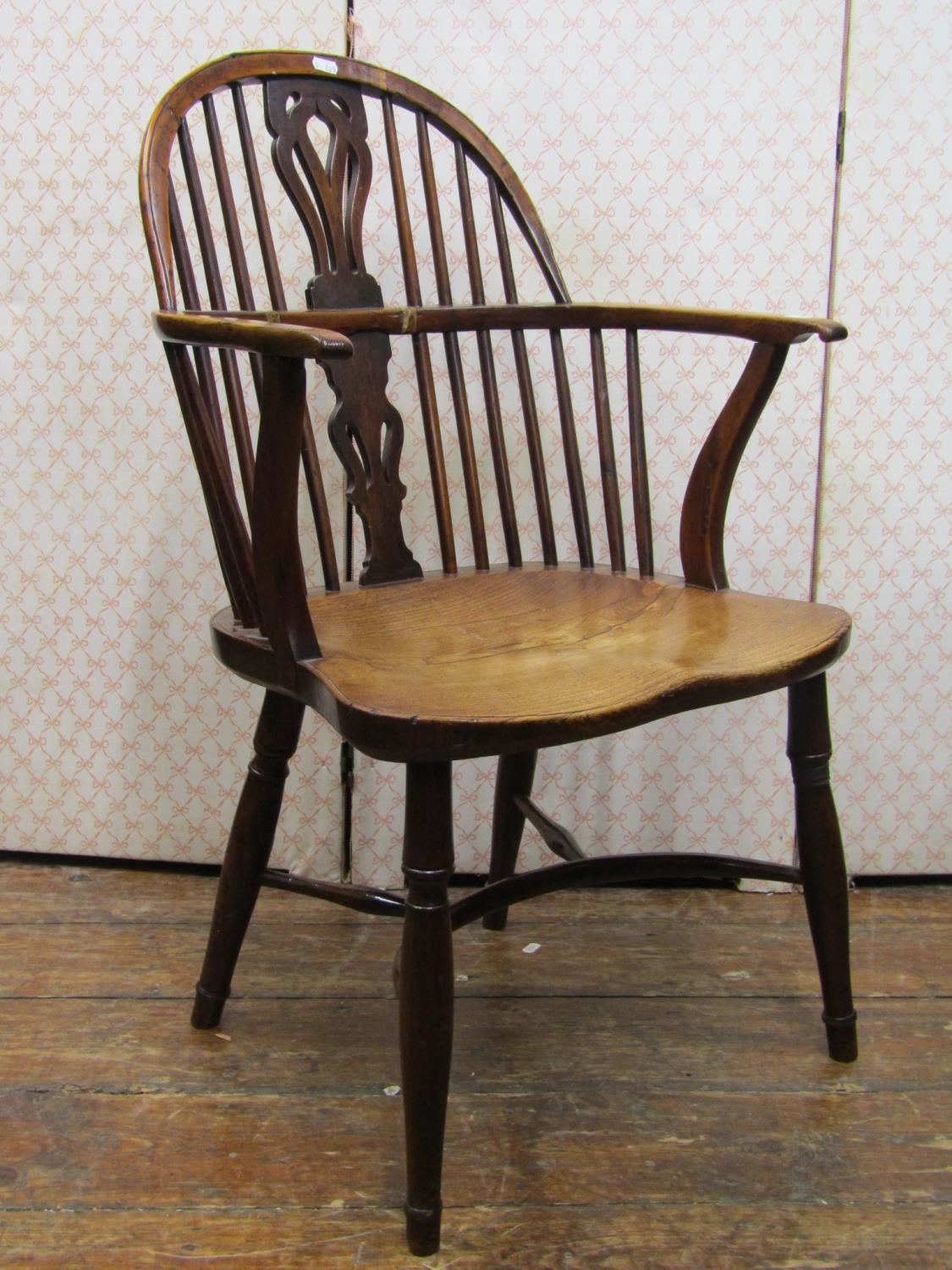 A Georgian Windsor gun back elbow chair in mixed woods, principally elm, fruit wood and yew wood,