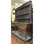 A Georgian oak pot board dresser with five drawers, the lower shelf supported on gun barrel