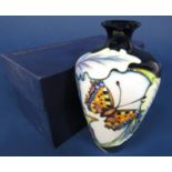 A boxed Moorcroft vase of shouldered form with painted butterfly decoration and impressed and