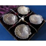 Cased set of four silver scallop shaped salts, upon three ball feet, maker LB, Birmingham 1984, with