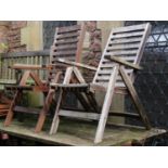 A pair of contemporary weathered stained hardwood folding garden armchairs with slatted seats and