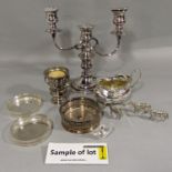 A mixed collection of silver plate comprising a twin branch candelabra, various wine coasters, tea