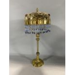 An unusual bohemian brass table lamp with Islamic type beaded shade and Regency style column 45cm