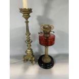 Brass Corinthian column oil lamp with cranberry reservoir together with a large brass table lamp