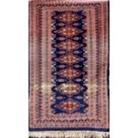 Unusual Bokhara type Kashmir rug, with central row of geometric medallion upon a navy blue ground,