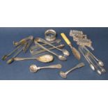 A mixed collection of silver and silver plate to include various sugar tongs, napkin ring, butter