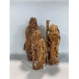 Two similar carved Chinese hardwood figures of standing sages, the largest 24cm high, together
