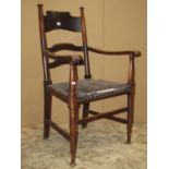 An Arts & Crafts open elbow chair with shaped splats over a rexine upholstered pad seat raised on