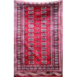 Turkamen Bokhara runner with typical geometric medallion decoration upon a red ground, 160 x 100cm