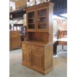 A stripped pine kitchen dresser, the base enclosed by a pair of square fielded panelled doors