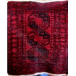 Small antique Turkamen rug with three medallions upon a deep red ground, 110 x 85cm