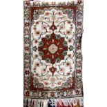 Small Persian full pile rug with central burnt orange medallion upon an ivory ground, 130 x 60cm
