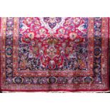 Persian Meshad carpet, decorated with central floral medallion and further still-lifes upon a red