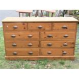 A reclaimed stripped pine dresser fitted with an arrangement of nine drawers with cast metal cup