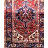 Good quality antique Hamadan rug with central blue medallion upon a red ground, 210 x 130cm