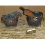 Two 19th century copper helmet shaped coal scuttles with loop handles, a set of three brass fire