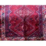 Persian Turkamen type three medallion rug, with blue details upon a red ground, 185 x 155cm