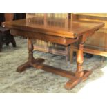 An oak drawleaf dining table of rectangular form raised on a pair of turned vase shaped column